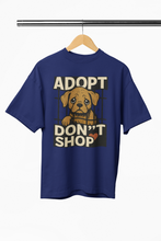 Navy blue t-shirt with a graphic of a dog and text 'ADOPT DON'T SHOP' on a hanger.