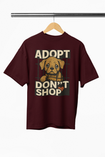 Maroon t-shirt with 'ADOPT DON'T SHOP' text and dog graphic on a hanger.