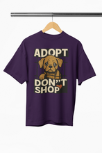 Purple t-shirt with a dog graphic and text 'ADOPT DON'T SHOP' on a hanger.