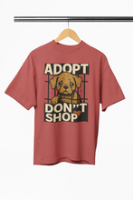 Red t-shirt with a dog graphic and 'Adopt Don't Shop' text on a hanger against a white background