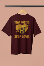 Maroon t-shirt with gold text and graphic on a beige background
