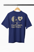 Navy blue t-shirt with graphic design and text 'Strong Minds. Kind Hearts.' on a hanger against a white background.