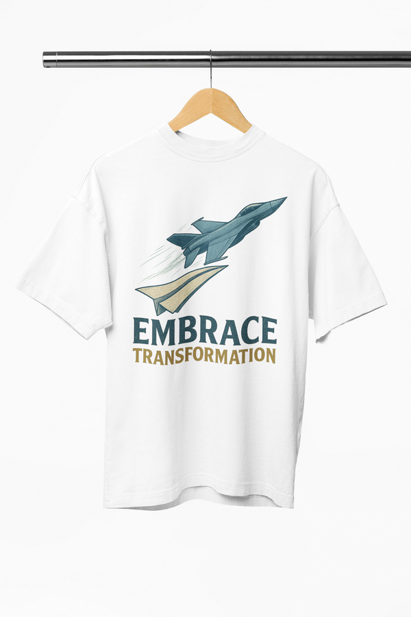 White t-shirt with airplane graphic and 'Embrace Transformation' text on a hanger.