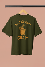Green t-shirt with 'My Blood Type? Chai+' text on a beige background