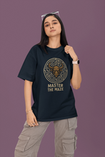 Person wearing a black t-shirt with a graphic design and text on a purple background