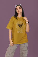 Person wearing a mustard yellow t-shirt with a graphic design and text on a purple background