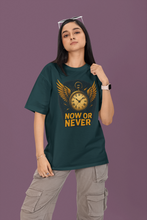 Person wearing a green t-shirt with a clock graphic and 'Now or Never' text on a purple background