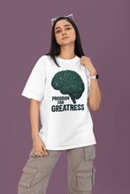 Person wearing a white t-shirt with a brain graphic and 'Program for Greatness' text on a purple background