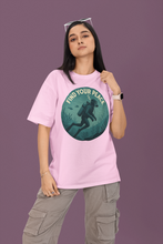 Person wearing a pink t-shirt with a graphic design and text on a purple background