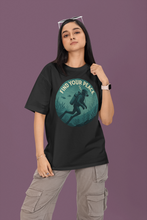 Person wearing a black t-shirt with a graphic design and text on a purple background