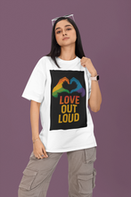 Person wearing a white t-shirt with a colorful 'LOVE OUT LOUD' design on a purple background