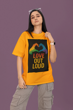 Person wearing a yellow t-shirt with a rainbow heart design and 'Love Out Loud' text on a purple background