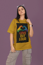 Person wearing a mustard yellow t-shirt with a rainbow heart and 'Love Out Loud' text on a purple background
