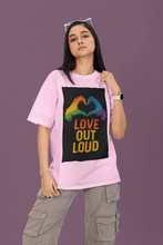 Person wearing a pink t-shirt with a rainbow heart design and 'Love Out Loud' text on a purple background