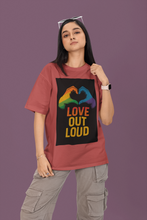 Person wearing a red t-shirt with a rainbow heart design and 'Love Out Loud' text on a purple background