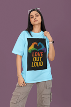 Person wearing a blue t-shirt with a colorful 'Love Out Loud' graphic on a purple background