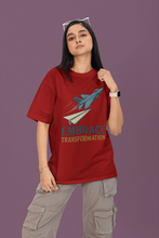 Person wearing a red t-shirt with a graphic and text on a purple background