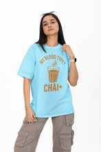 Person wearing a light blue t-shirt with a graphic and text, standing against a white background
