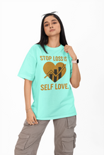 Person wearing a light blue t-shirt with a motivational message on a white background
