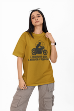 Person wearing a mustard yellow t-shirt with a graphic design and text on a white background