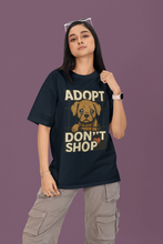 Person wearing a black t-shirt with 'Adopt Don't Shop' text and dog graphic on a purple background