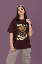 Person wearing a t-shirt with an 'Adopt Don't Shop' graphic on a purple background