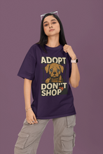 Person wearing a purple t-shirt with a dog adoption message on a purple background