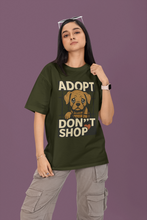Person wearing a green t-shirt with an 'Adopt Don't Shop' message on a purple background