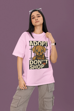 Person wearing a pink t-shirt with an 'Adopt Don't Shop' graphic on a purple background
