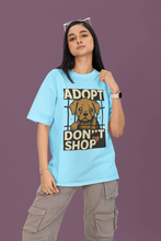 Person wearing a blue t-shirt with an 'Adopt Don't Shop' graphic on a purple background