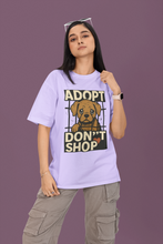 Person wearing a purple t-shirt with an 'Adopt Don't Shop' graphic on a purple background