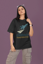 Person wearing a black t-shirt with a graphic and text on a purple background