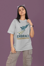 Person wearing a t-shirt with a graphic and text 'Embrace Transformation' on a purple background
