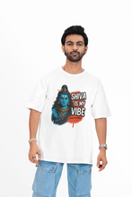 white t-shirt with 'Shiva is my vibe' design against a colorful abstract wall.